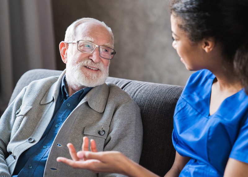 Home-health-aide-interacting-with-senior-male